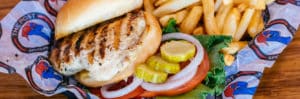 Grilled chicken sandwich with lettuce tomato, onion and side of fries