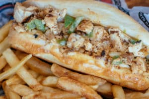 Chicken Cheesesteak sandwich prepared with onions, green peppers, and white America. Served on a toasted hoagie with Fries