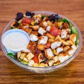 Chicken Club Salad with Breaded chicken, bacon, egg, mixed greens, tomato, cheddar jack & croutons.  Served w/ranch