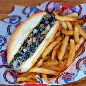Portabella mushroom cheesesteak with green pepper, onion & white American cheese.  Served on a toasted hoagie bun with fries