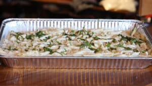 Penne pasta catering tray topped with homemade alfredo sauce, with or without blackened chicken