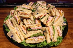 Club Sandwich catering tray with Smoked turkey, sliced ham, bacon, lettuce, tomato, cheddar & mayo on whole wheat bread