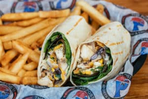 Southwest Wrap with Marinated chicken, spring mix, cheddar jack, & jalapeno ranch wrapped in a white tortilla. Served with fries