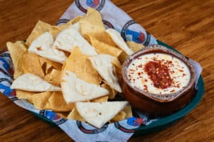 Beer cheese queso dip made with Homemade beer cheese queso dip served w/pita points and chips