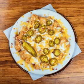 Tater Tot appetizer smothered with bacon, jalapenos, & cheddarjack