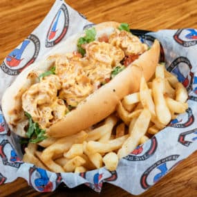Shrimp Po Boy Sandwich tossed in bang bang sauce. Served on a toasted hoagie with lettuce, tomato and side of fries