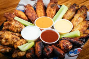 Chicken Wing appetizer sampler platter with hot sauce, beer cheese sauce, honey mustard, and ranch