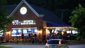 The Post Sports Bar & Grill in Fenton storefront at night with a st.Louis Blues crowd outside